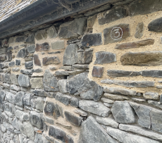 Image of a stone wall different sections of mortar repairs